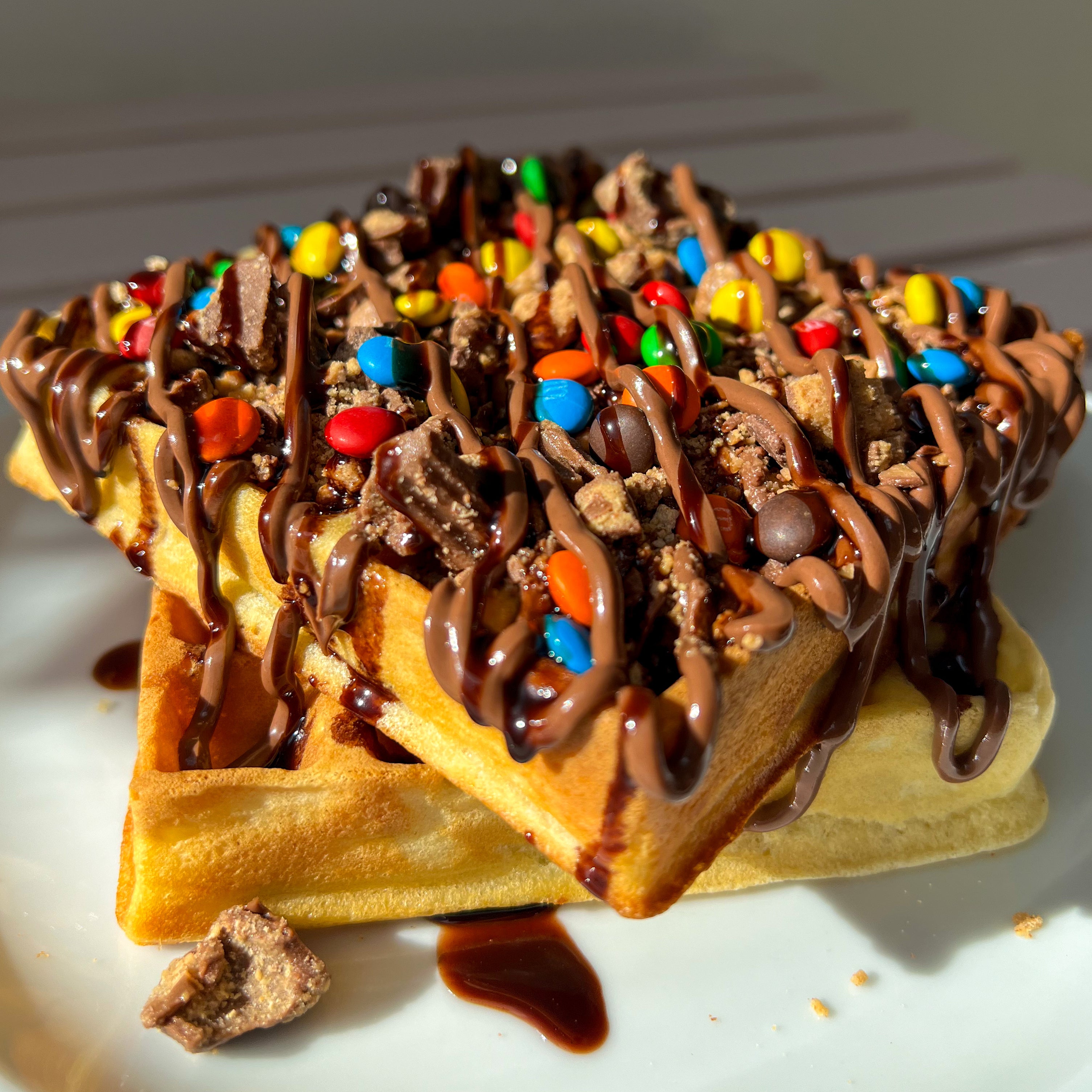 Nana's fluffy buttermilk waffle topped with 4 chocolates of your choice (Skor, Twix, Reese's, M&M, Smarties, Maltesers, KitKat, Oreo, Sprinkles). Drizzled with Nutella & chocolate fudge.