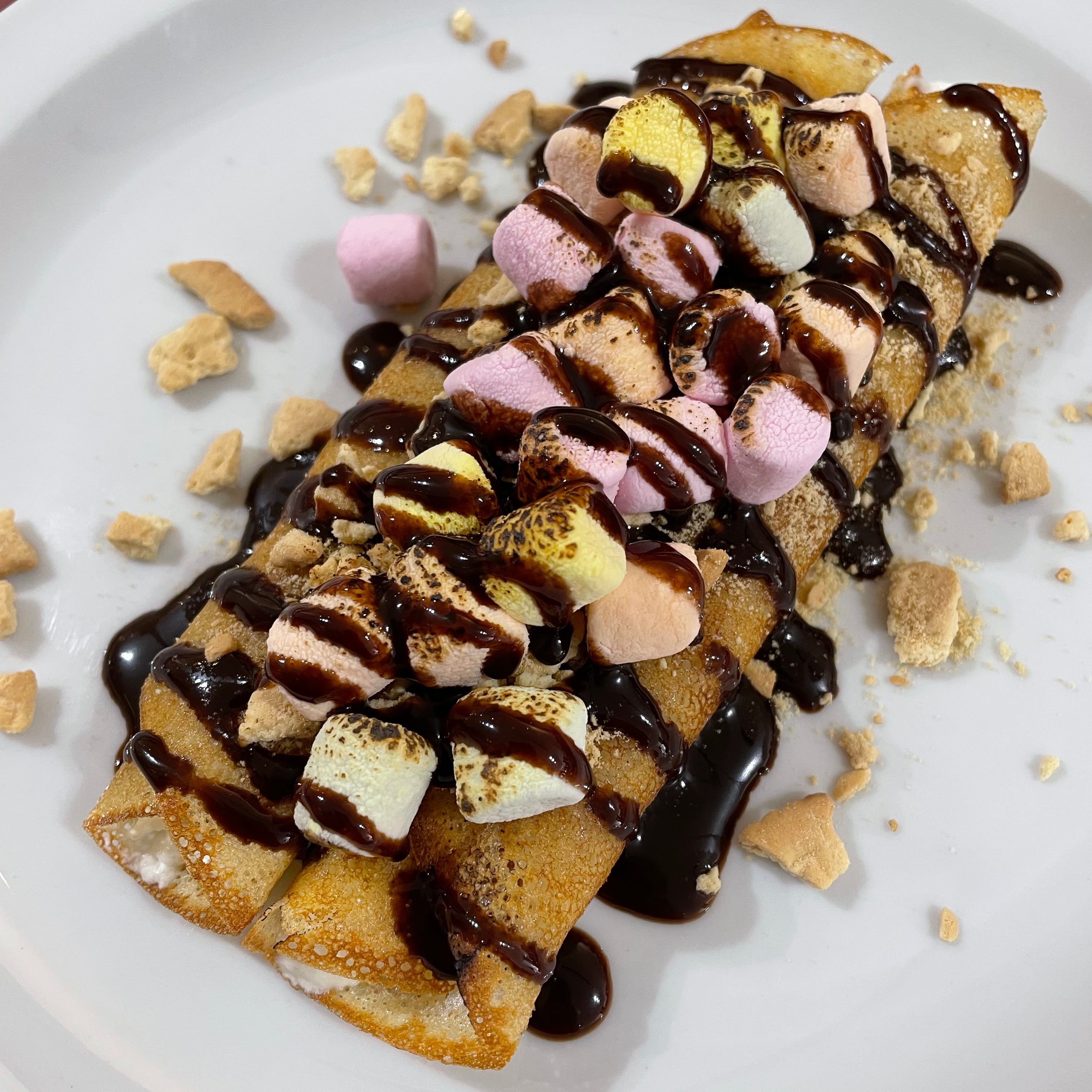 S'mores Crepe with marshmallow, cookies and chocolate drizzle. Unique dessert in Toronto